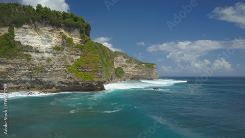 Large cliff in a remote location weathers the crashing of strong ocean currents.