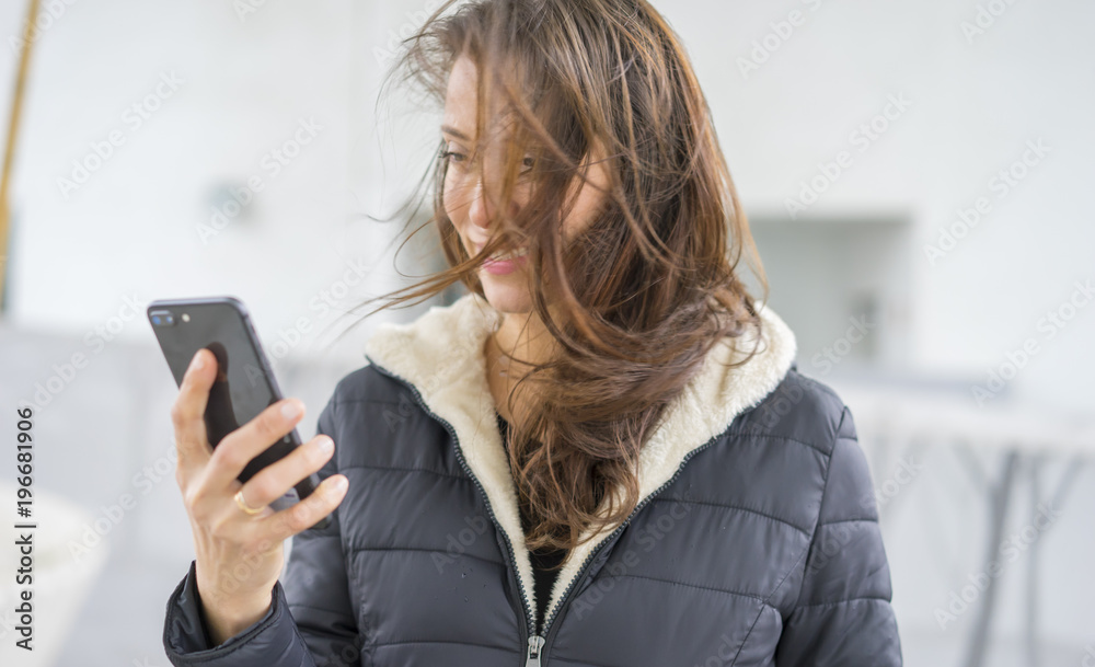 Adult, Brown-haired woman in video conference with the mobile. talking on the street with your partner through the use of new technologies Adult, Brown-haired woman in video conference with the mobile. talking on the street with your partner through the use of new technologies