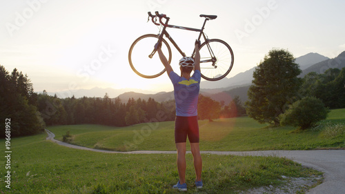 LENS FLARE: Unrecognizable young man celebrating his road cycling race victory.
