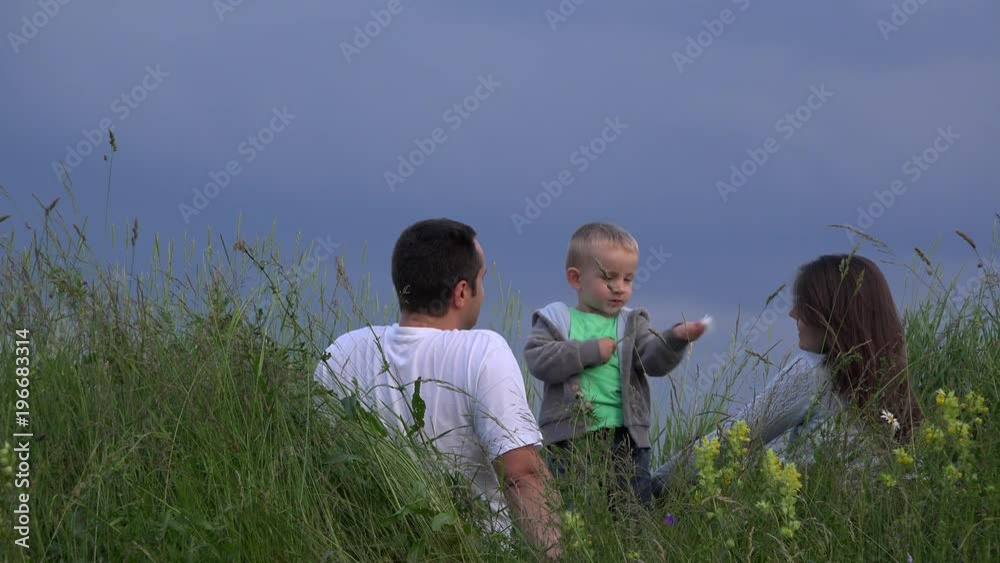 Family having fun outdoor, child playing with flower parents laughing, sky 4K Family having fun outdoor, child playing with flower parents laughing, sky 4K