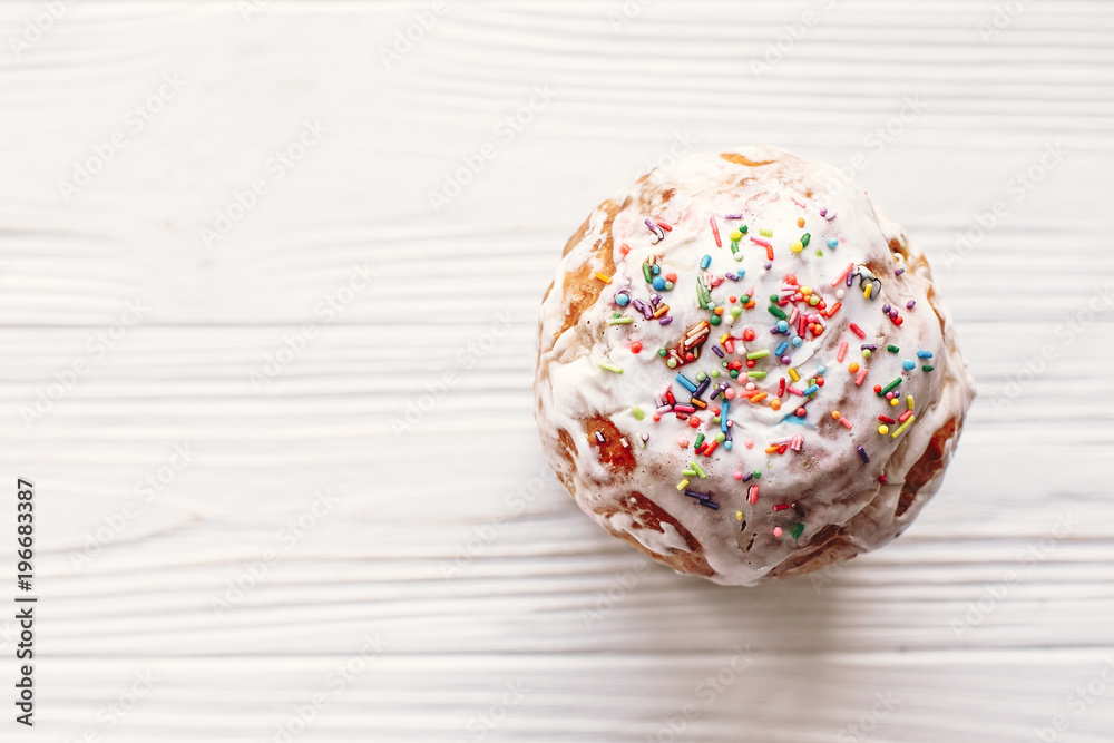 delicious easter cake with colorful icing on white rustic wooden background top view. space for text. happy Easter concept, flat lay. seasons greetings