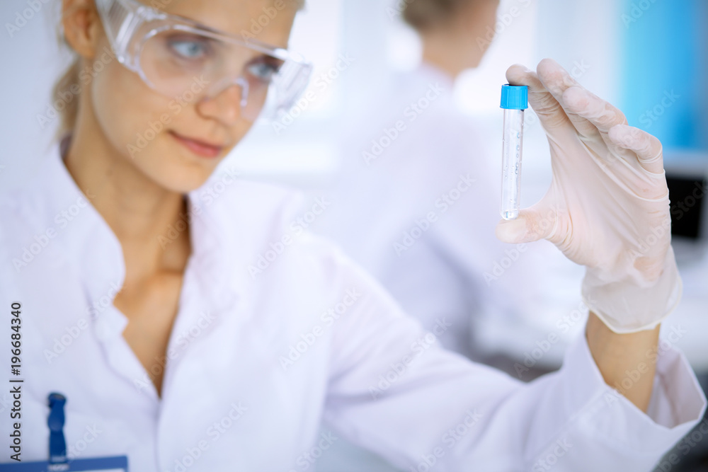 Female scientific researcher in laboratory studying substances or blood sample. Medicine and science concept Female scientific researcher in laboratory studying substances or blood sample. Medicine and science concept