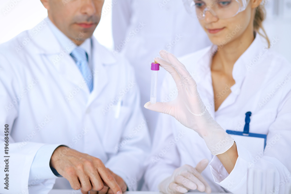 Team of scientific researchers in laboratory studying substances or blood sample. New vaccine for pharmacology industry is s almost ready. Medicine and science concept Team of scientific researchers in laboratory studying substances or blood sample. New vaccine for pharmacology industry is s almost ready. Medicine and science concept