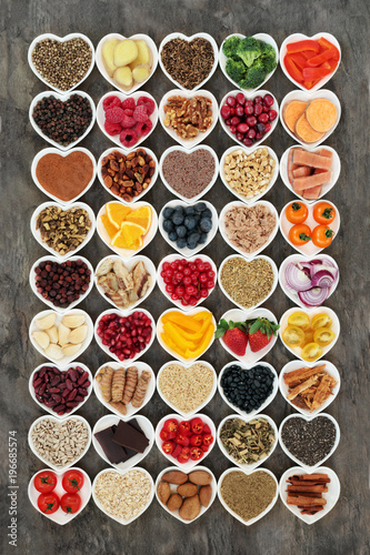 Healthy food concept with fruit, vegetables, fish, seeds, nuts, grains, cereals, herbs and spices also used in herbal medicine to promote heart health. Super foods high in omega 3 & antioxidants. 