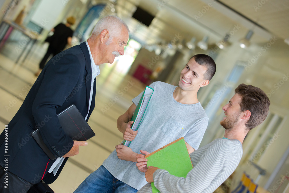 professor talking to students in the hallway