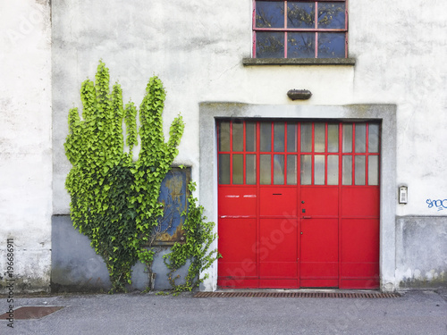 Red iron doorway in old industrial building in Italy photo