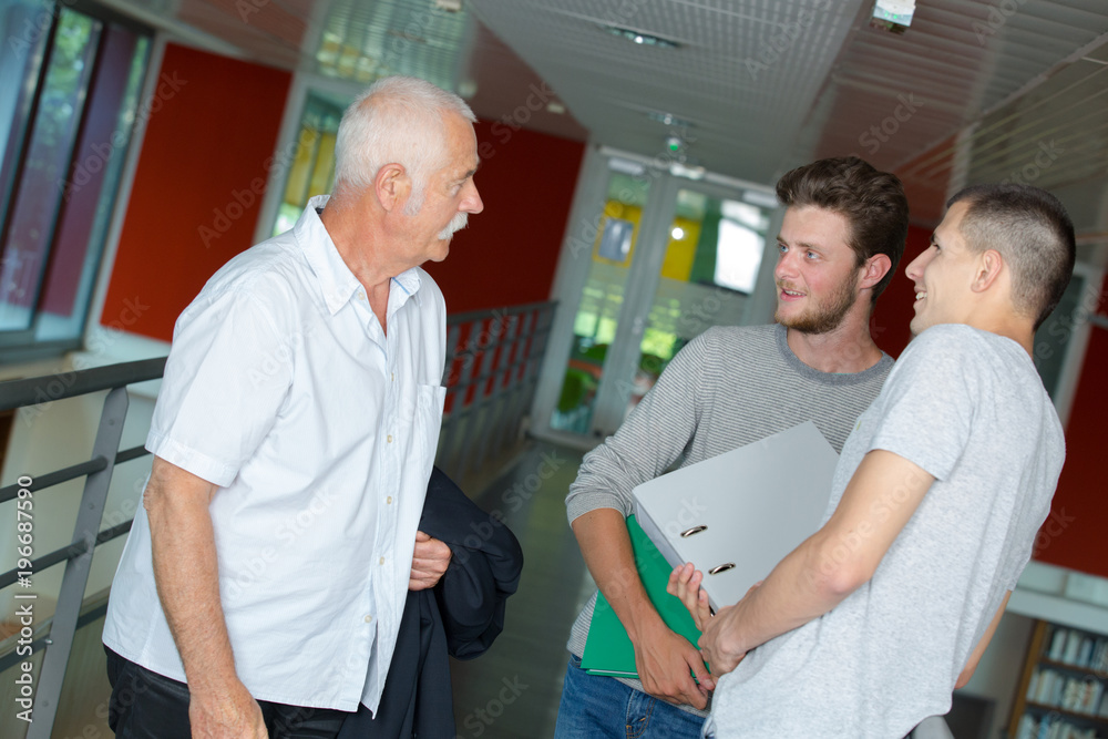Fototapeta premium three men having a conversation on the hallway