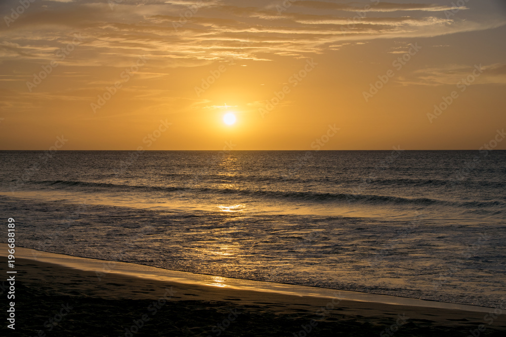 Setting sun reflecting over a calm still ocean Setting sun reflecting over a calm still ocean