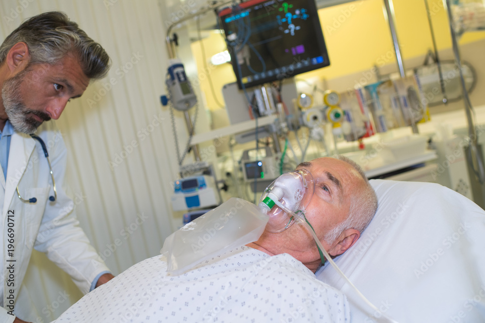 senior man using oxygen mask in clinic senior man using oxygen mask in clinic