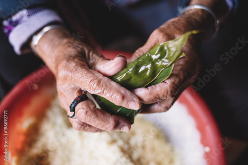 The old woman is wrapping rice dumplings photo