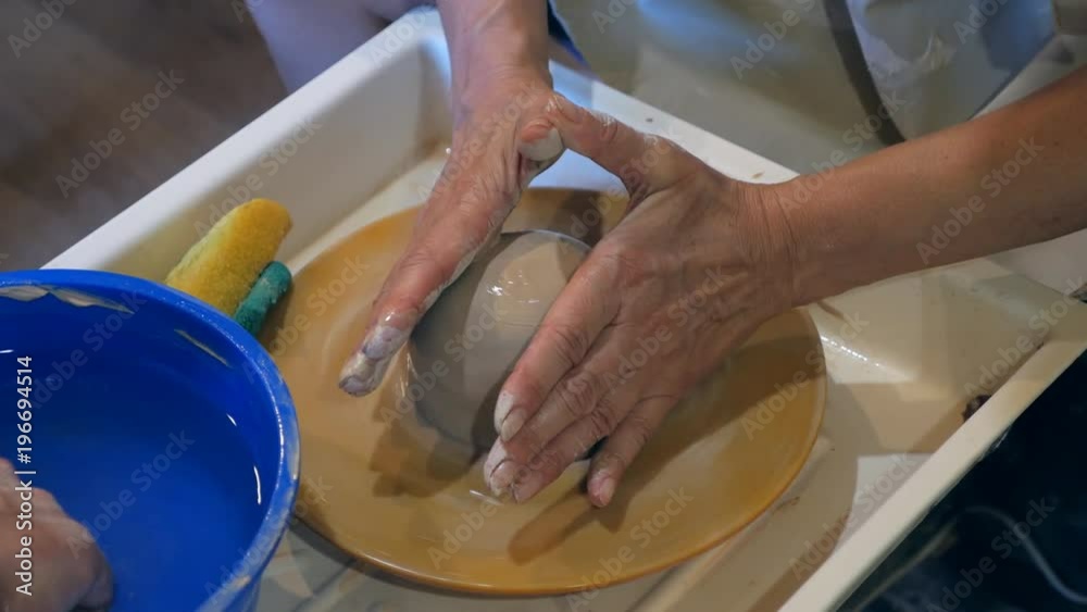 Master and apprentice make a pot on pottery wheel Master and apprentice make a pot on pottery wheel