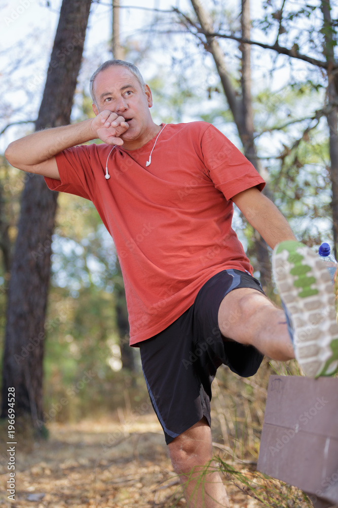 handsome middle aged man stretching outdoors