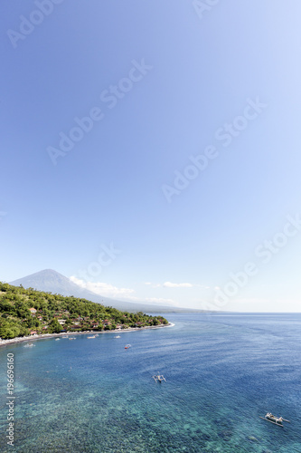 View of Amed village Agung volcano shallow reef and jukung boats floating in the bay of Jemeluk in Bali photo