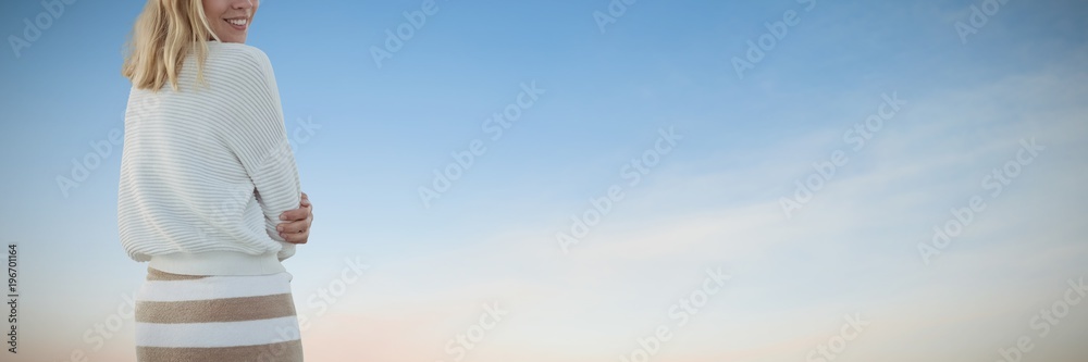 Composite image of portrait of smiling beautiful woman with arms