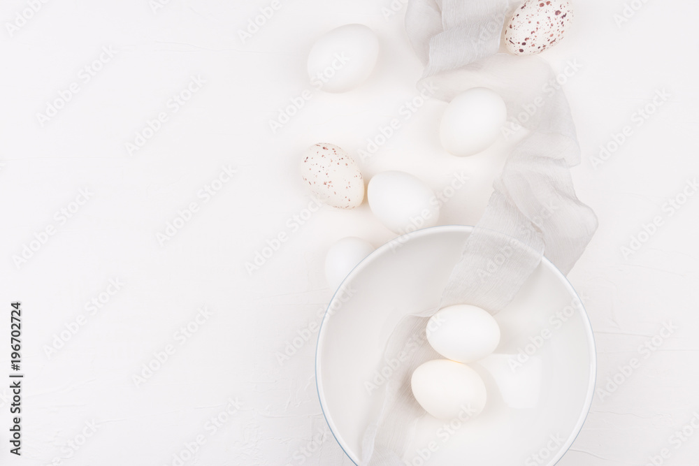 Stylish background with white and yellow easter eggs in bowl and silk fabric with space for text. Isolated on white background. Flat lay, top view. Easter concept. Stylish background with white and yellow easter eggs in bowl and silk fabric with space for text. Isolated on white background. Flat lay, top view. Easter concept.