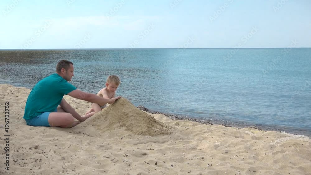 Father and son building a sandcastle, endless sea
