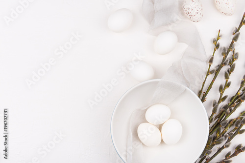Stylish background with white easter eggs in bowl, goat willow and silk fabric with space for text. Isolated on white background. Flat lay, top view. Easter concept.