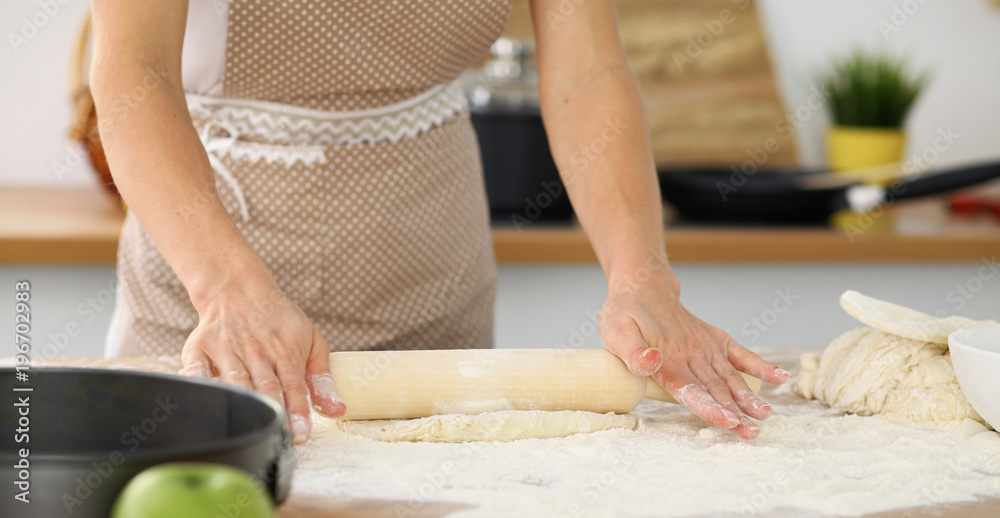 Female hands making dough for pizza or bread while using rolling pin. Baking concept Female hands making dough for pizza or bread while using rolling pin. Baking concept