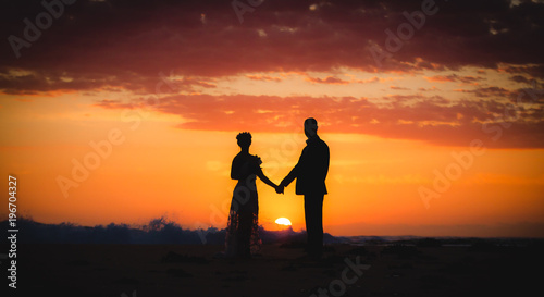 couple lover holding hand on the beach during sunrise morning sky