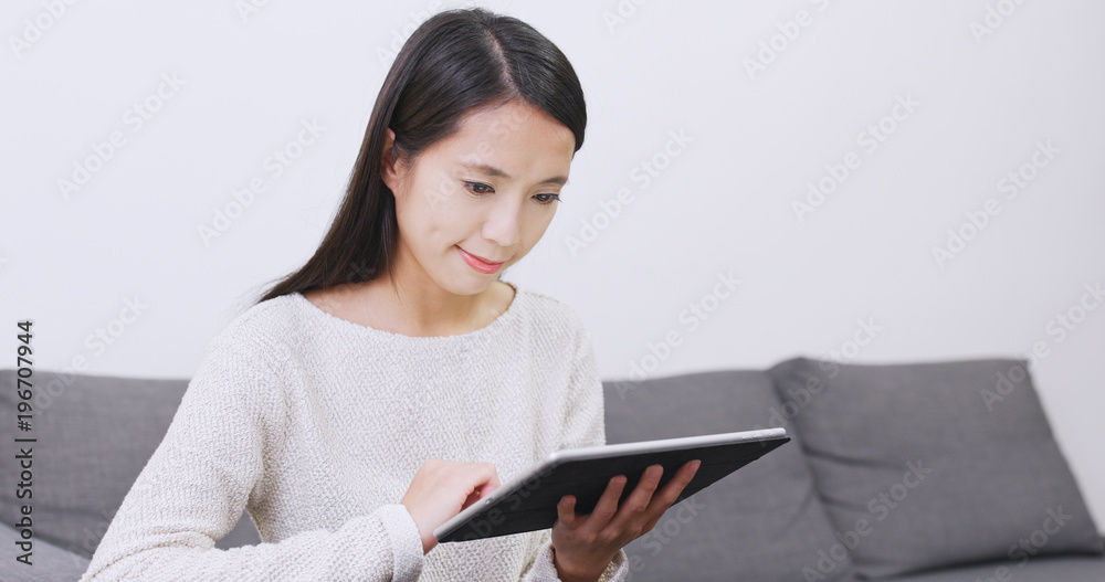 Asian Woman using tablet computer at home