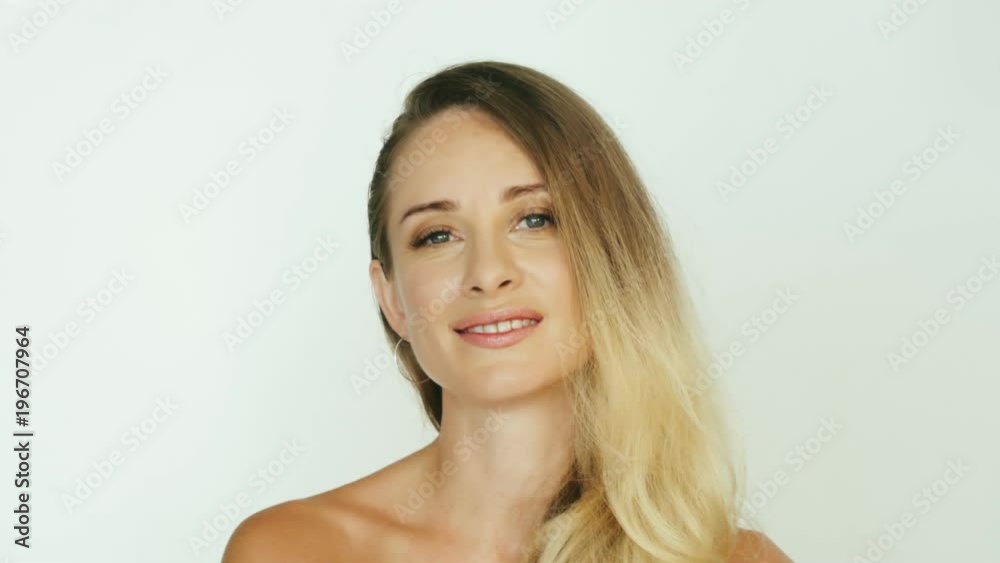 Smiling woman pointing with finger up and winking eye on white background Smiling woman pointing with finger up and winking eye on white background