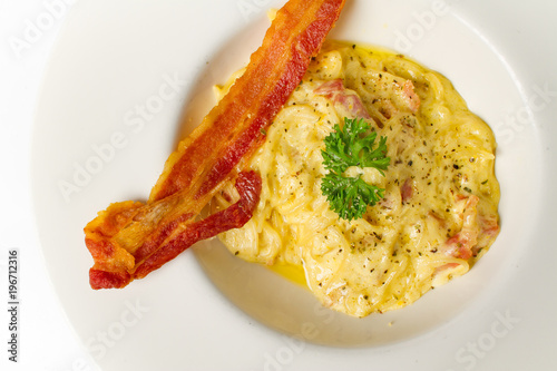 spaghetti carbonara white cream sauce with crispy bacon on white background photo