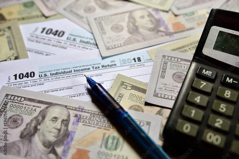 US Tax form 1040 with US dollar note. US Tax form 1040 with US dollar note.