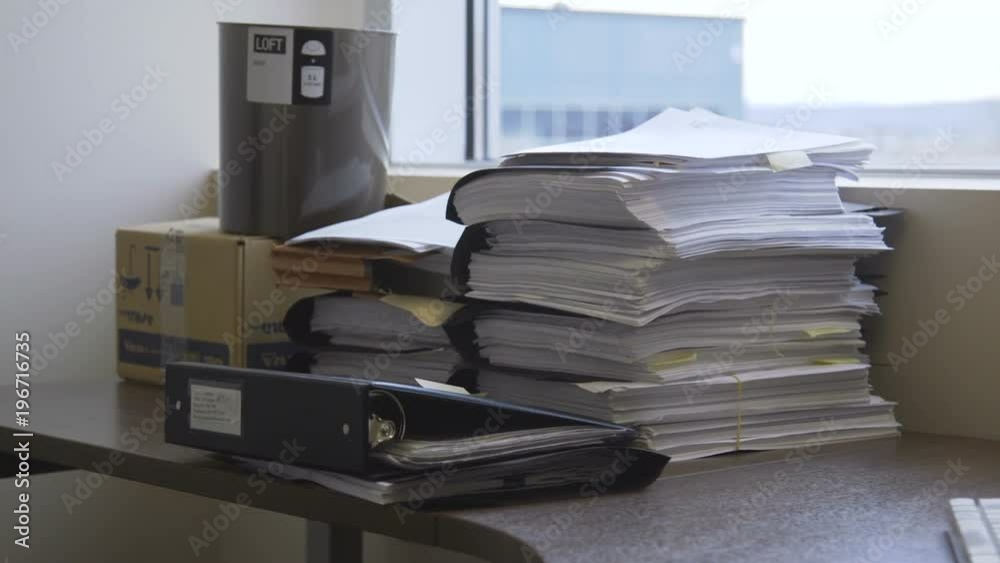 Stack of office files, records and binders on a desk