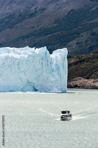 Boat cruising along lake in front of Perito Moreno Glacier photo