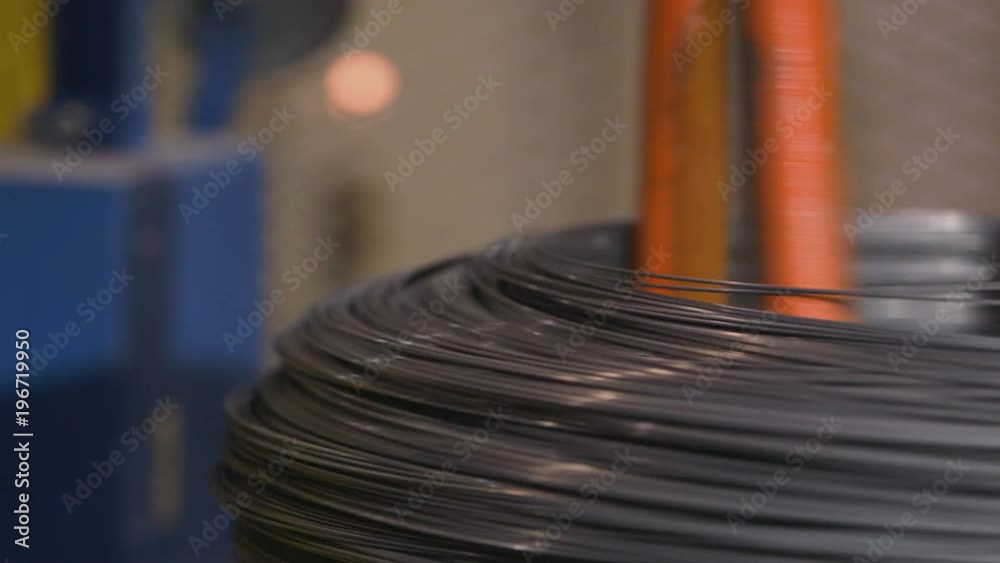 Metal spring coils being wound in a factory Metal spring coils being wound in a factory