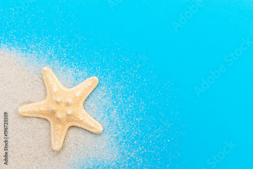 Starfish with sand on a blue. Top view. Summer background.