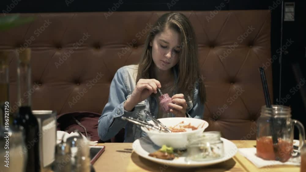 Teenage girl eating dessert sitting in cafe
Teenage girl eating dessert sitting in cafe
