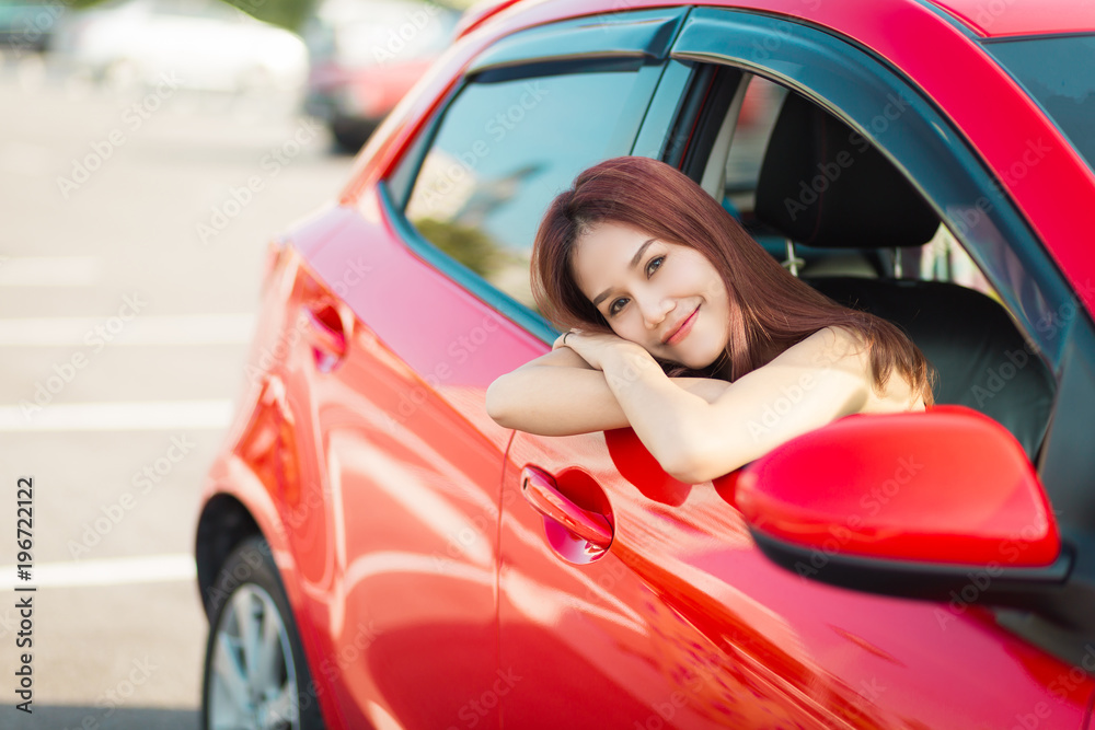 Beautiful asian woman enjoying life  in the red car.