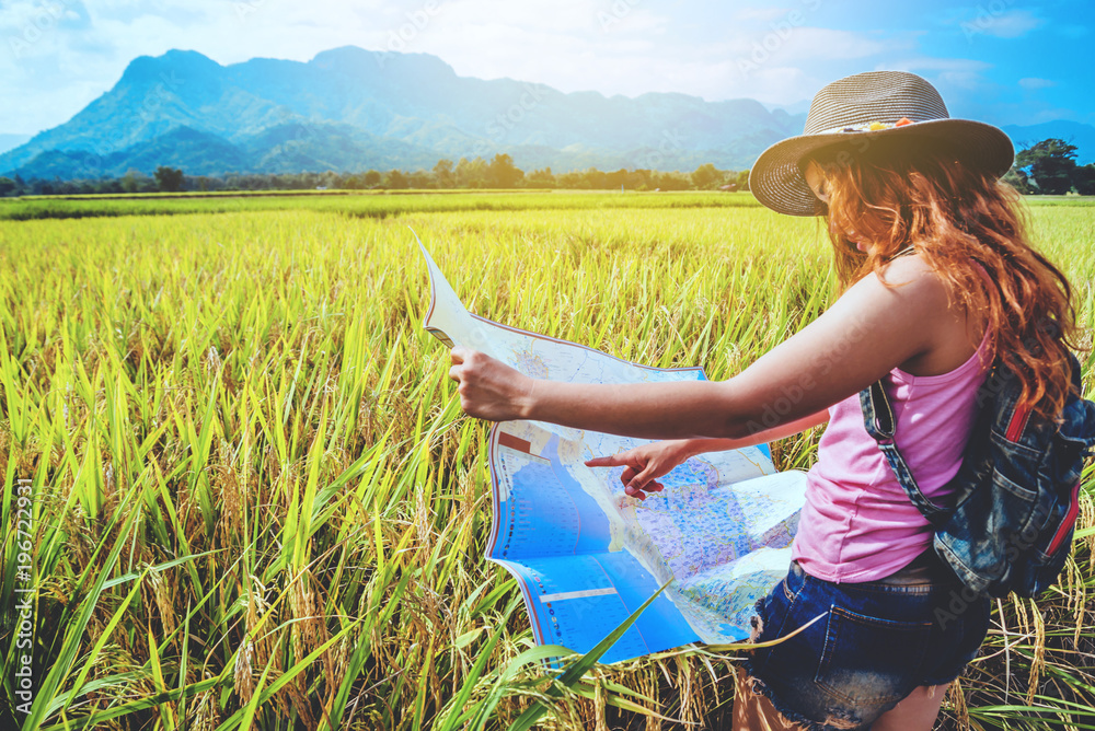 Fototapeta premium Asian women travel relax in the holiday. Stand natural touch mountain field summer. View map travel explore. In Thailand