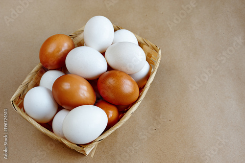A lot of white and brown eggs in a straw basket