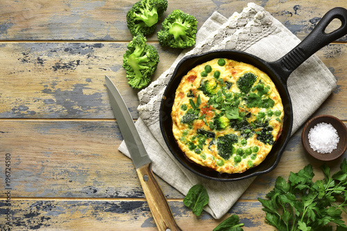 Spring omelette with green vegetables (broccoli, sweet pea and spinach) in a skillet.Top view.