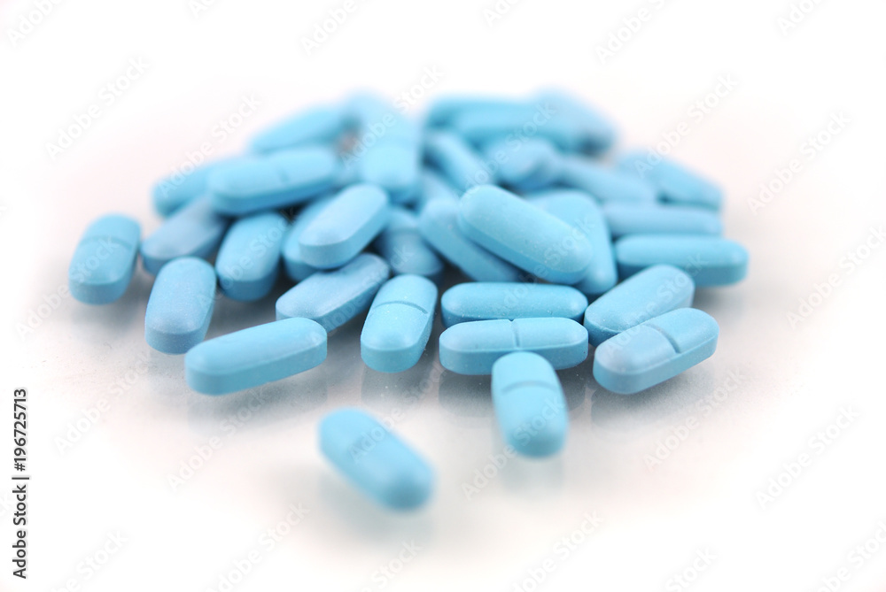 Oval blue tablets closeup on white background Oval blue tablets closeup on white background
