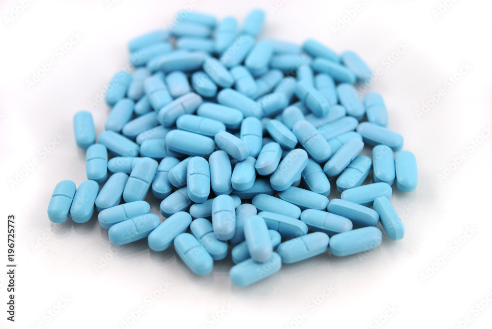 Oval blue tablets closeup on white background Oval blue tablets closeup on white background