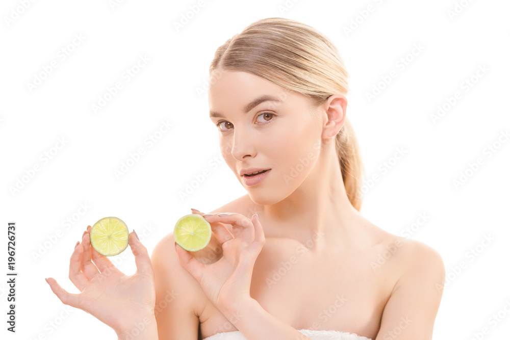 The beautiful woman holding two halves of a lime on the white background The beautiful woman holding two halves of a lime on the white background