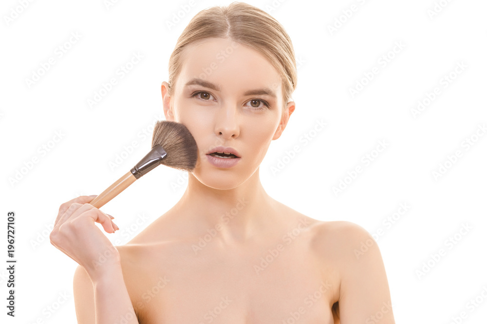 The cute woman using a cosmetic brush on the white background The cute woman using a cosmetic brush on the white background