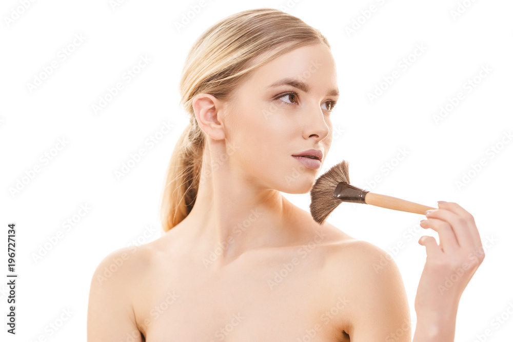 The beautiful woman using a cosmetic brush on the white background The beautiful woman using a cosmetic brush on the white background