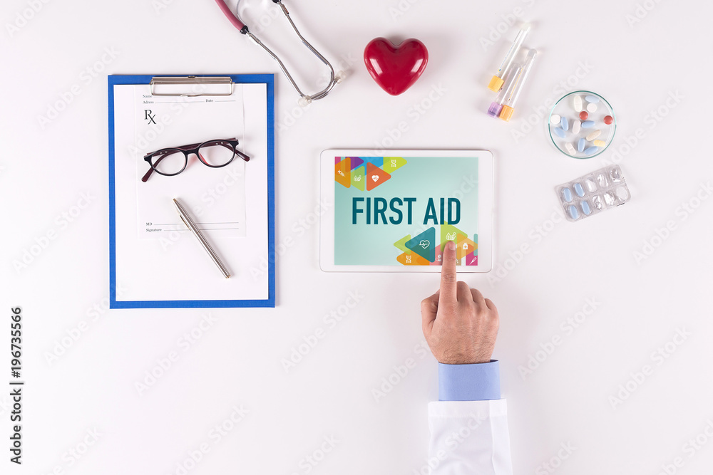 Doctor workplace with FIRST AID on tablet screen Doctor workplace with FIRST AID on tablet screen