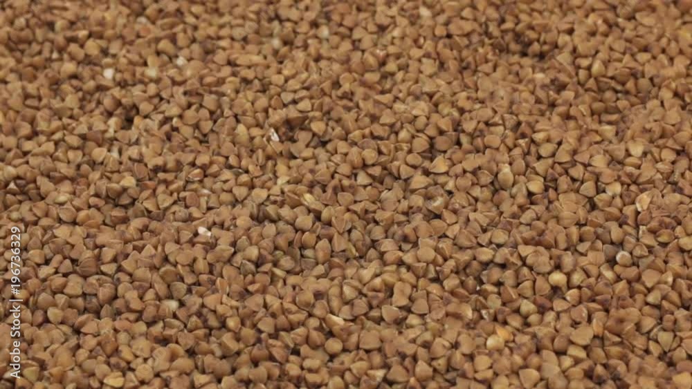 Rotation, background made from a pile of buckwheat grains. Rotation, background made from a pile of buckwheat grains.