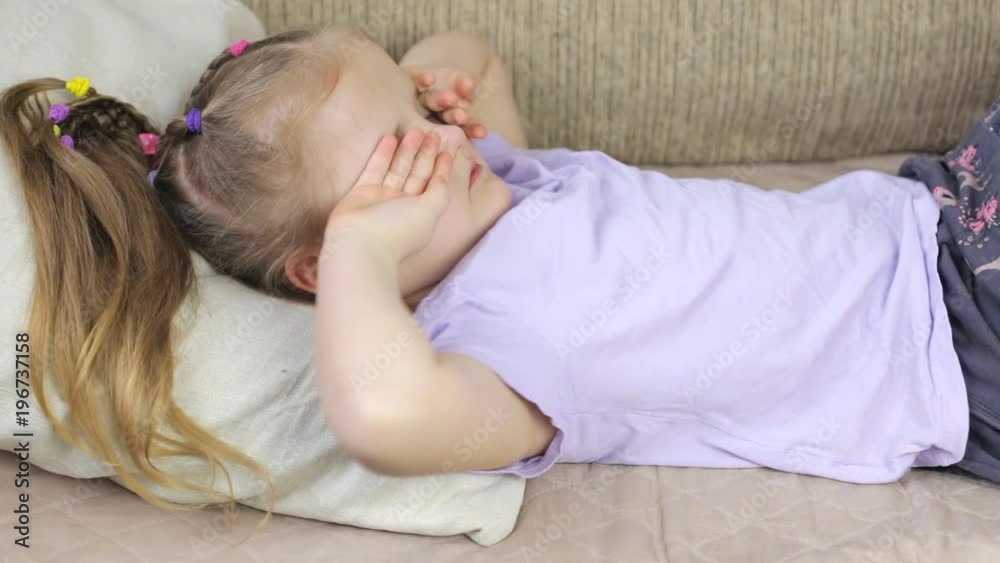 Cute young girl rubs her eyes at home. Eyes rubbing Cute young girl rubs her eyes at home. Eyes rubbing