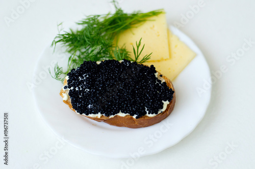 caviar sandwich on a white plate with cheese