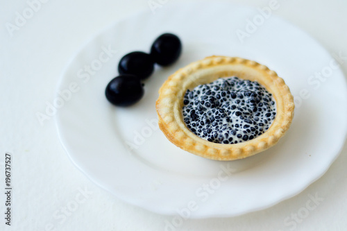 tartlet with caviar and herb on a white plate
