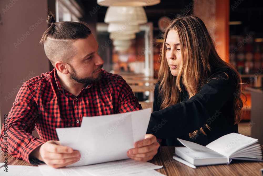 colleagues discuss documents sitting in a cafe colleagues discuss documents sitting in a cafe