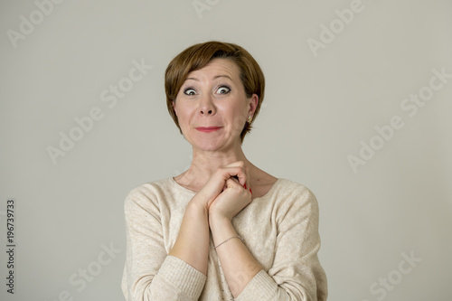 young happy and surprised red hair woman looking to camera delighted astonished and in surprise face expression isolated on grey background