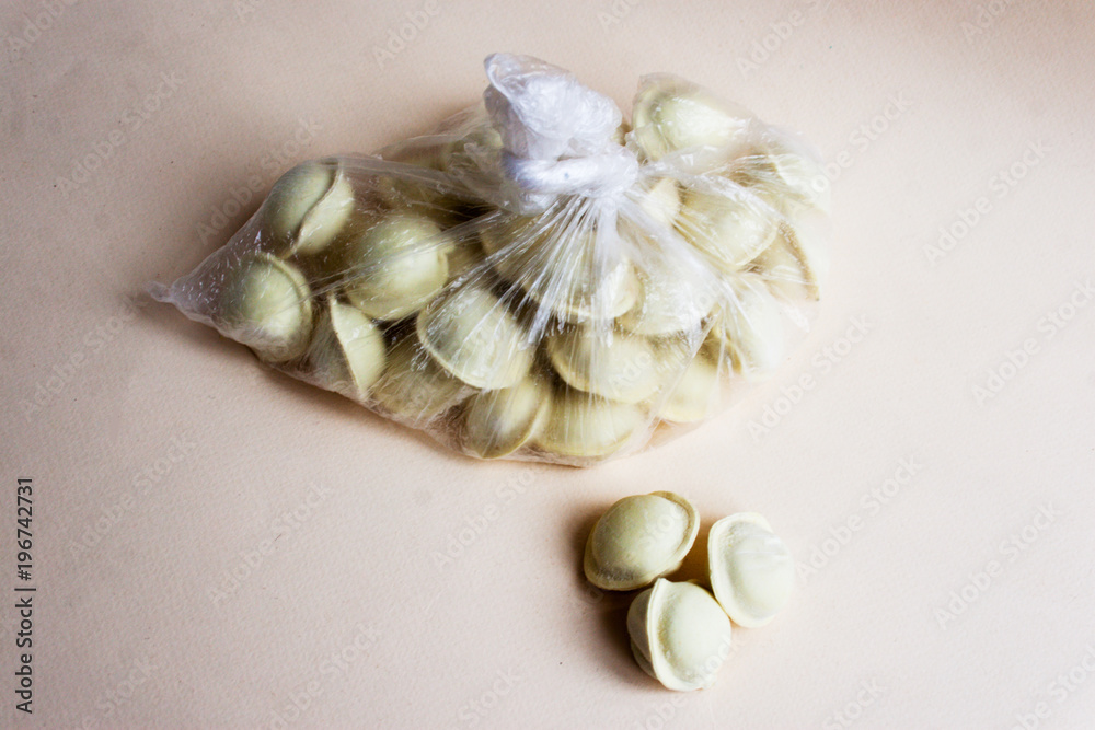 Dumplings in a cellophane bag on a light background. Three dumplings separately. Dumplings in a cellophane bag on a light background. Three dumplings separately.