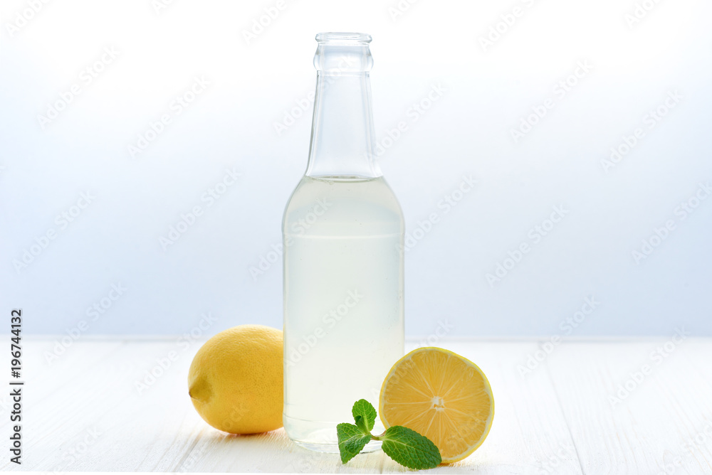 Citrus lemonade water with lemon sliced , healthy and detox water drink in summer on white wooden table with apple, oranges and lemons. Citrus lemonade water with lemon sliced , healthy and detox water drink in summer on white wooden table with apple, oranges and lemons.
